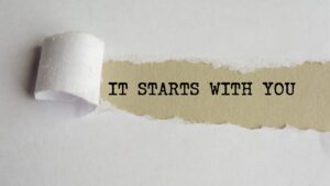 ripped paper with the typed words 'it starts with you'